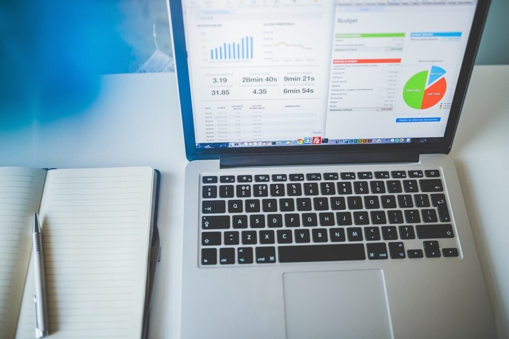 Laptop dan spreadsheet untuk merencanakan kenaikan budget iklan Facebook secara bertahap
